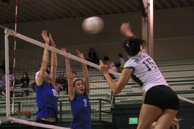 Starting outside hitter Maddie Kuppe (12) hits cross-court shot against Los Altos defenders Natalie Dwulet (13) and Meghan Cyron (12). The Lady Vikes defeated the Eagles in three games.