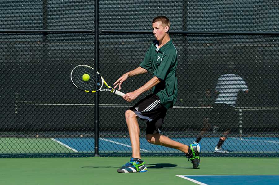 Blake Smith (14) slices a backhand. Smith plays number two singles for the Vikings.