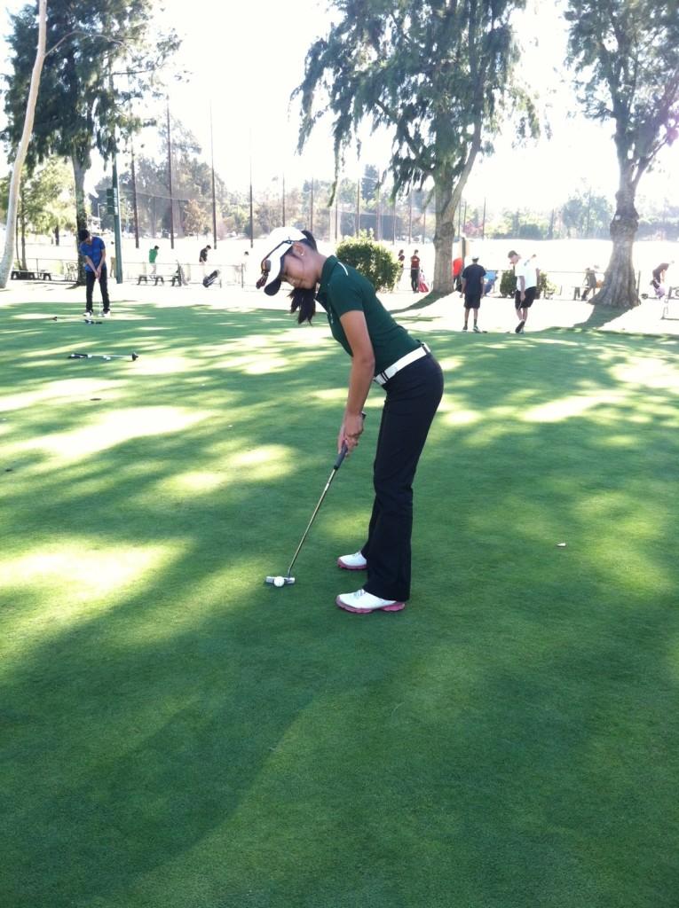 Michelle Xie (15) putts during practice.  Xie is one of the two captains of the team this year.  