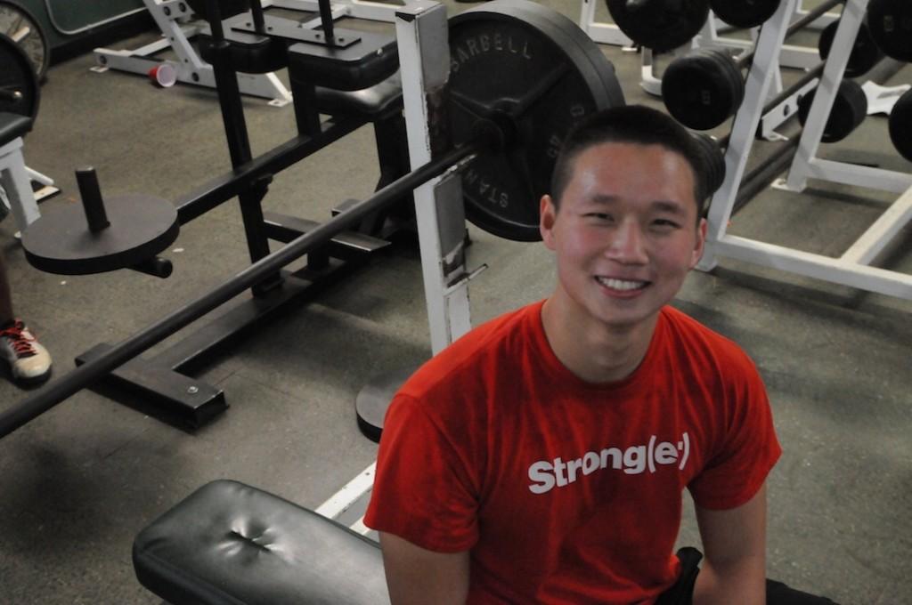 Andrew Lau (‘14) flashes a smile for the camera during his lifting workout in the Paly weightroom. Lau trains in the weightroom after school ends almost everyday for up to two hours.