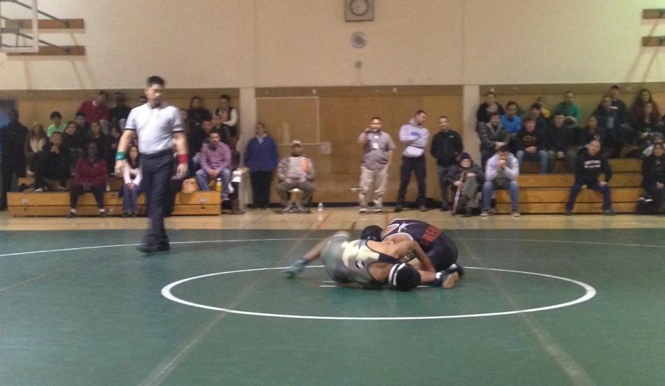 Seth Goyal (17) wrestles with his Fremont opponent. Goyal went on to win his match 16-10.