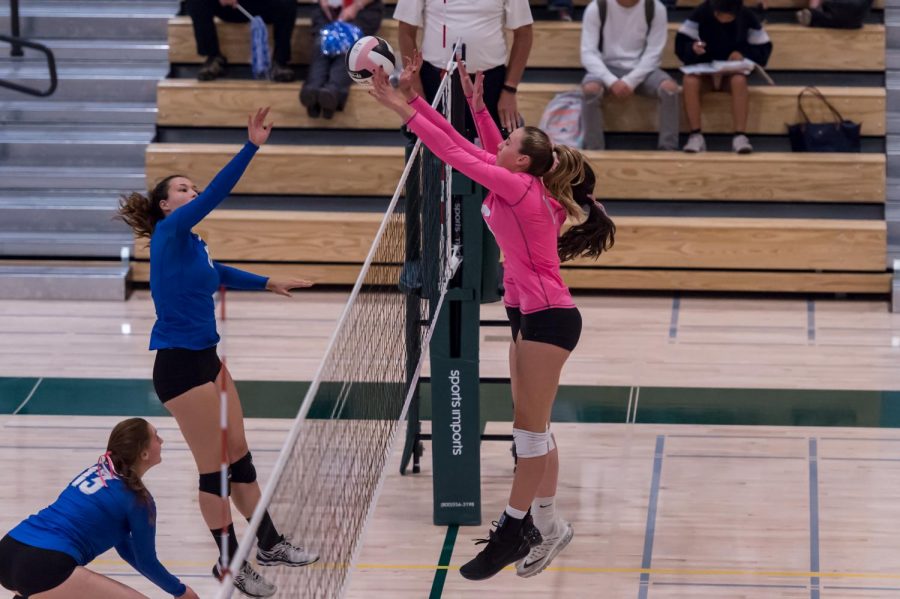Amelia Gibbs (18) and her teammate go up for a block.