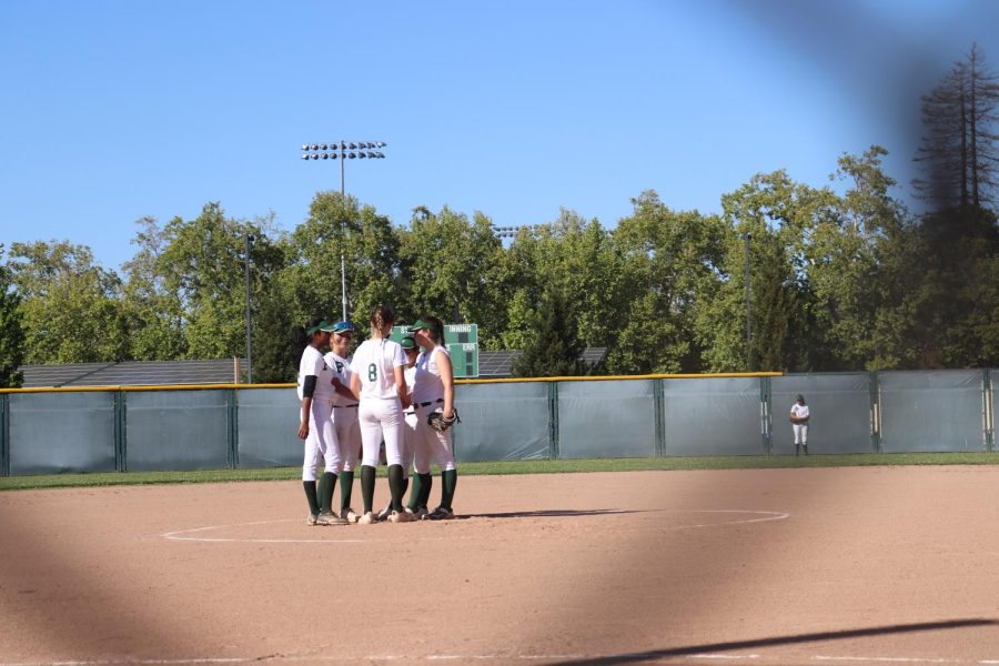 The team gathers on the mound before a game. Photo by Grace Gormley